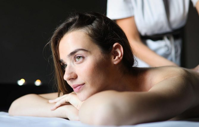 Young and healthy woman in spa salon. Traditional Swedish massage therapy and beauty treatments.