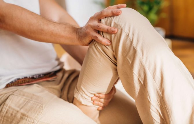 Traditional Thai Leg Massage.  Masseur performing relaxing passive stretching technique on a leg